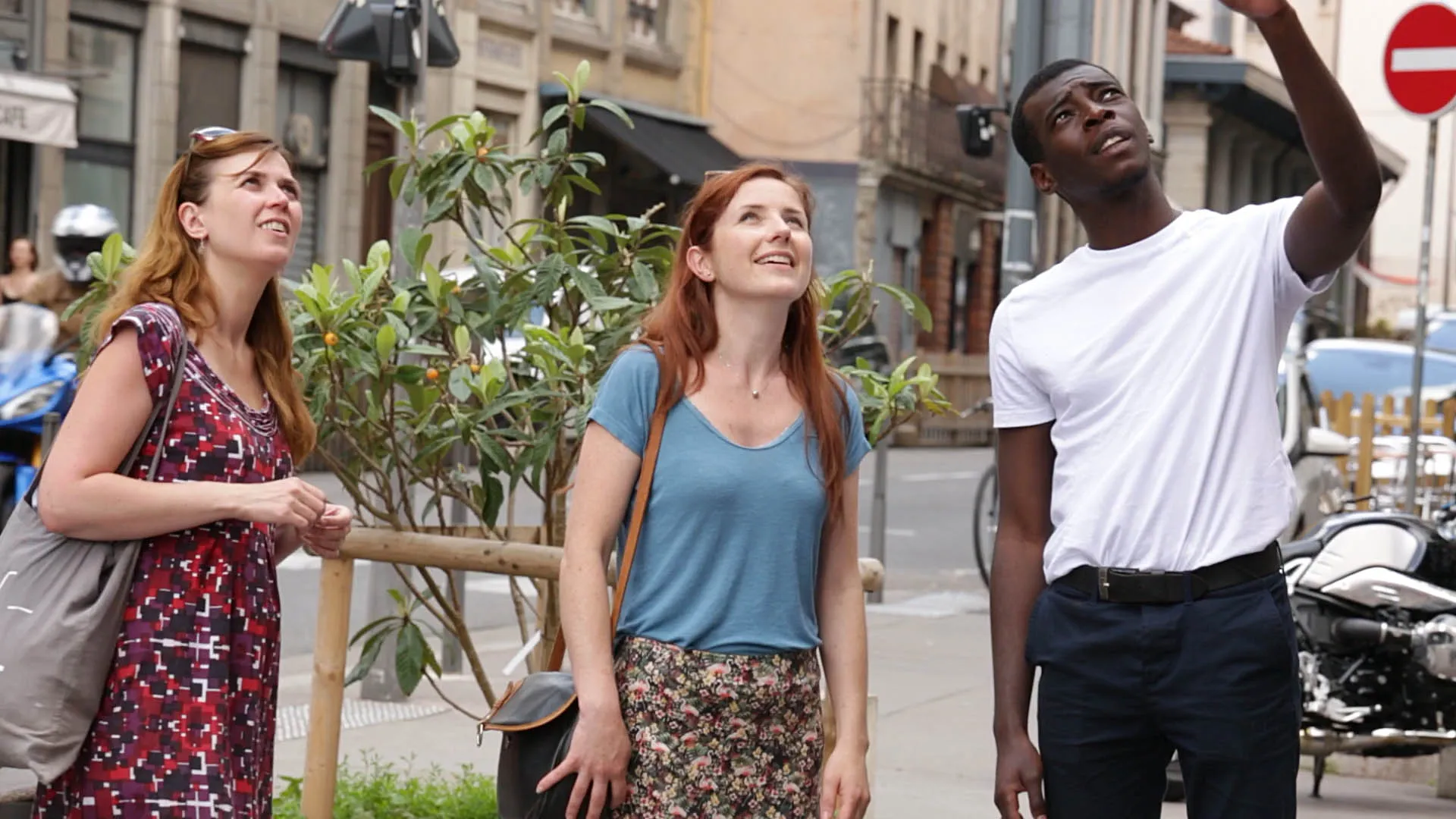 Three people look off screen at a mural.